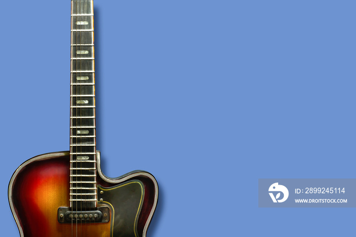 Old, jazz electric guitar on a blue background. Copy space. Background for music festivals, concerts.Musical education. Concert concept.