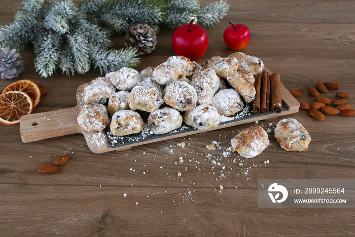 Stollenkonfekt mit Äpfeln und Zimtsangen auf einem Küchenbrett.