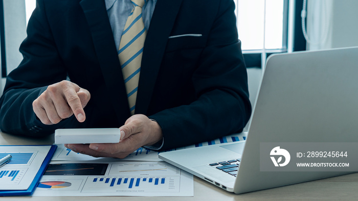 Businessman’s hands pressing a calculator, calculating, analyzing, graphing, charting, accounting worker working on a laptop. A bank clerk who advises making financial reports or company profits.