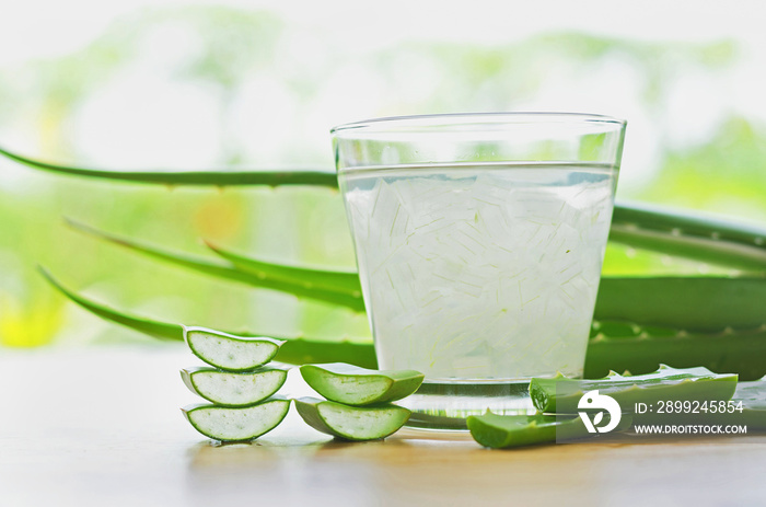 fresh aloe vera leaves and aloe vera juice in glass on wooden background