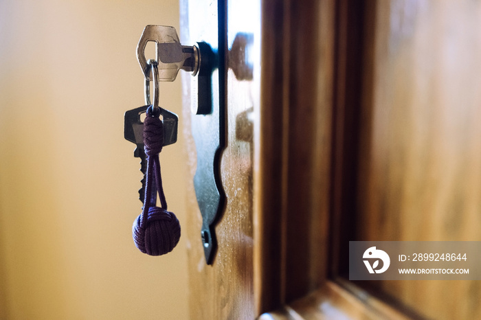 Door of a rural hotel room, with the key in the lock.