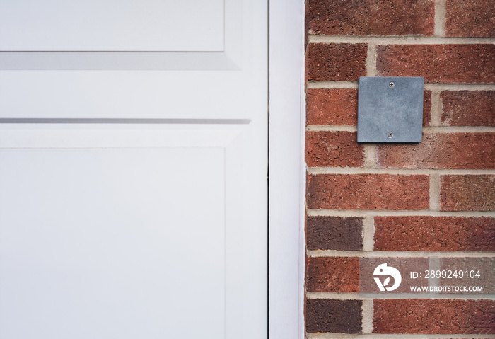 Grey slate plaque on a stone wall for the indication of house number, Empty plate board hang on Brick wall background or Brown concrete block for replace number for house address