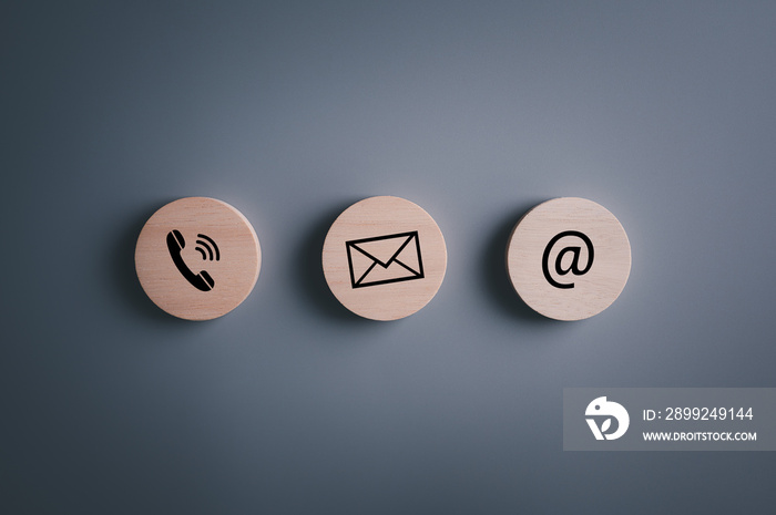 E-mail address ,telephone number and letter icons print screen on circle wooden block on table for webpage business contact and customer service concept..