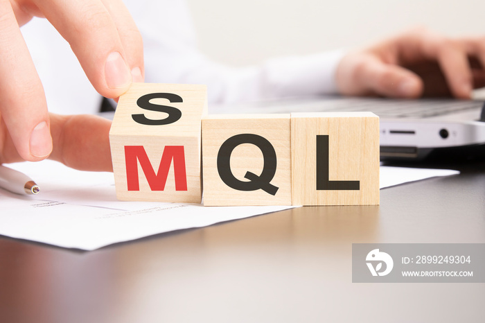 SQL or MQL symbol. hand turns cubes and changes words ’SQL sales qualified lead’ to ’MQL marketing qualified lead’.