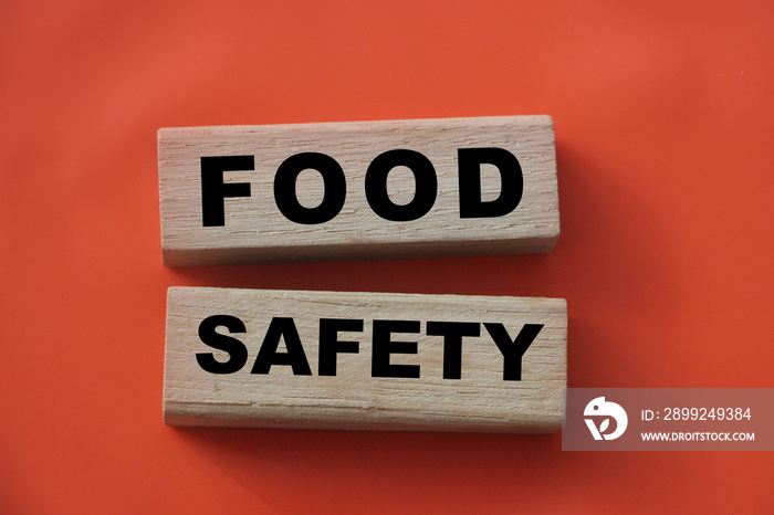 Wooden block form the word FOOD SAFETY on tomato red background. Medical healthcare concept