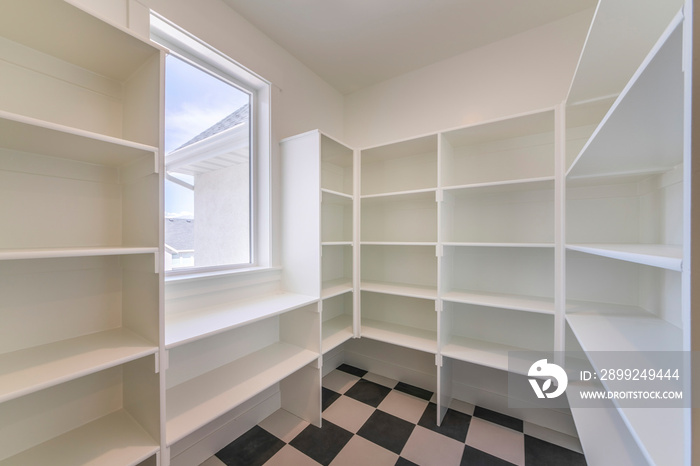 Interior of an empty kitchen pantry in a house with window