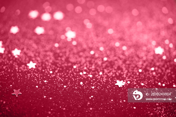 Beautiful Christmas viva magenta light background. Abstract glitter star bokeh and scattered sparkles