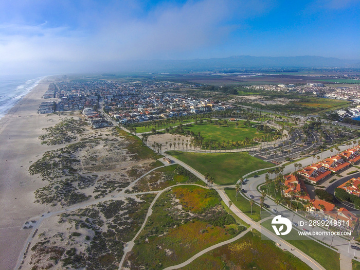 a stunning aerial shot of the beach front homes and city of Oxnard surrounding Oxnard State Beach Park in Oxnard California USA