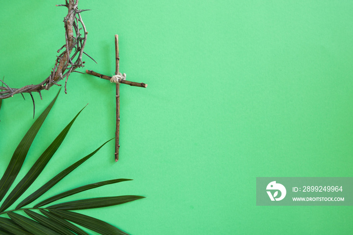 Border of Christian cross, crown of thorns and palm branch on a green background with copy space