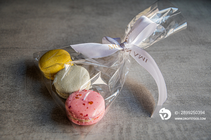 French macaroons folded in a cellophane bag tied with a white ribbon.