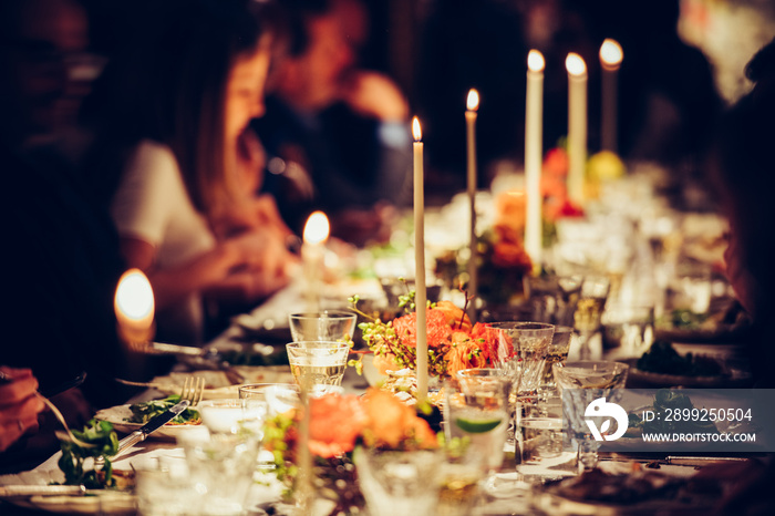 People dining at table with candles