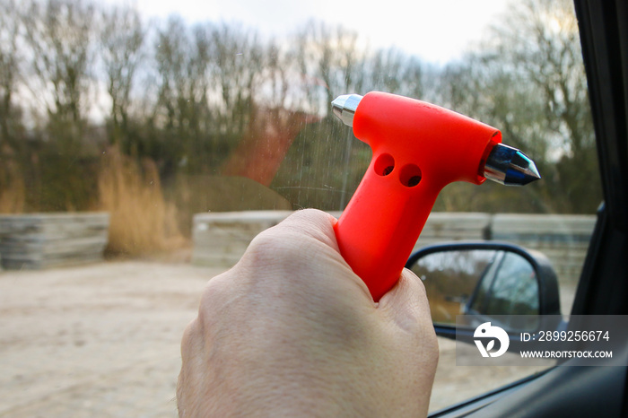 Safety hammer with  being used to break driver side window during car crash emergency