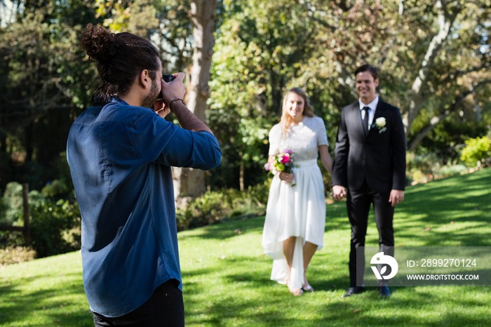 Photographer taking photo of newly married couple