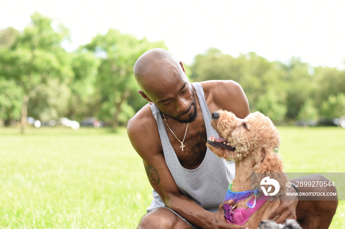 USA, Louisiana,�Man with dog sitting on lawn in park