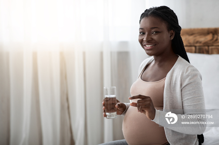 Prenatal Vitamins. Pregnant Black Woman Holding Supplement Pill And Glass Of Water