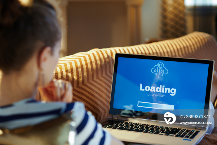 healthy woman looking at computer loading screen on laptop