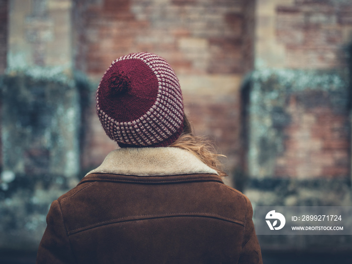 Woman with winter hat by wall