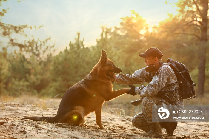 Military working dog giving paw to soldier outdoors