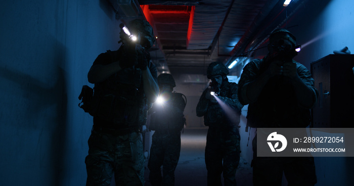 Soldiers with flashlights inspecting dark corridor