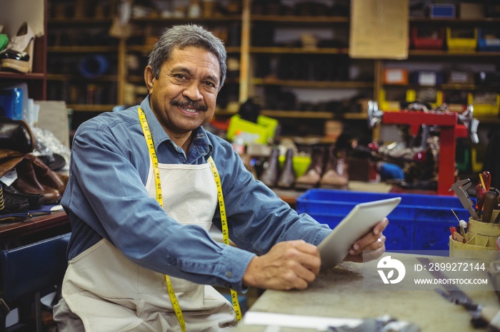 Portrait of shoemaker using digital tablet