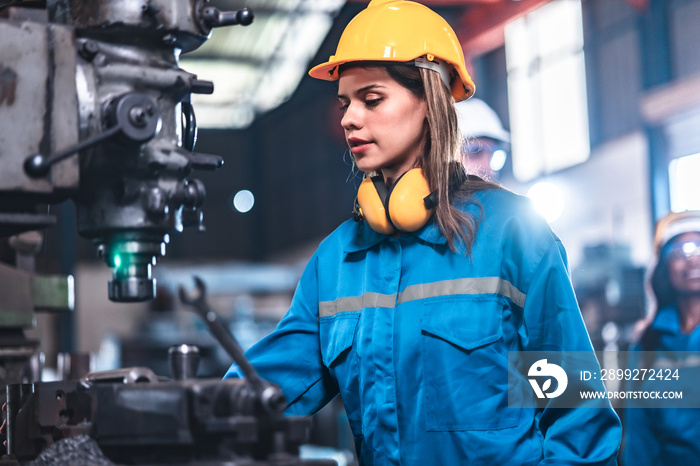 young woman smiling and working engineering in industry.Portrait of young female worker in the factory.Work at the Heavy Industry Manufacturing Facility