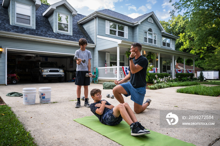 Air Force service member trains with his sons in a morning workout in preperation for a PT fitness test.