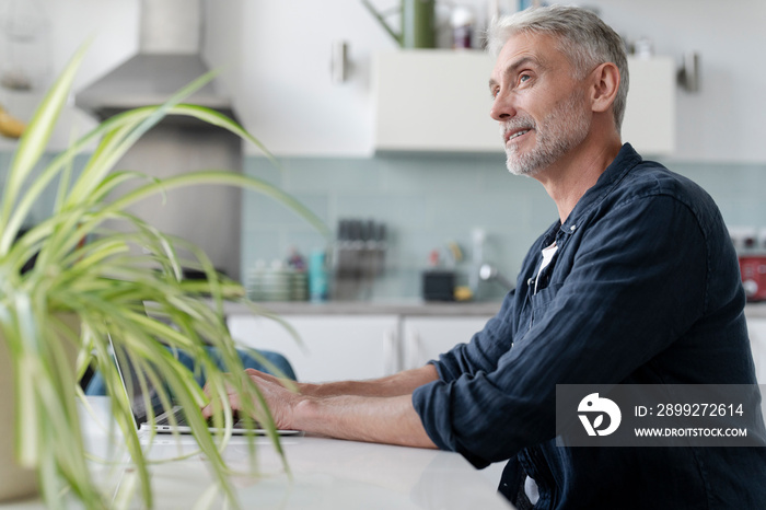 Mature man working on laptop at home