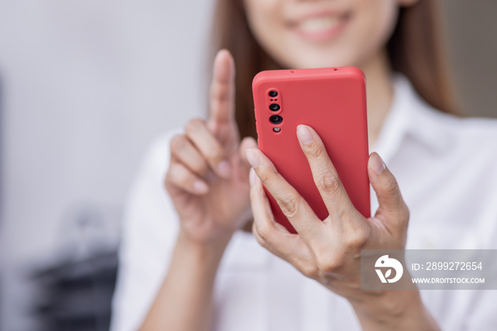 Happy Excited Asian young entrepreneur business woman using phone and laptop sitting on a desk at home workplace,