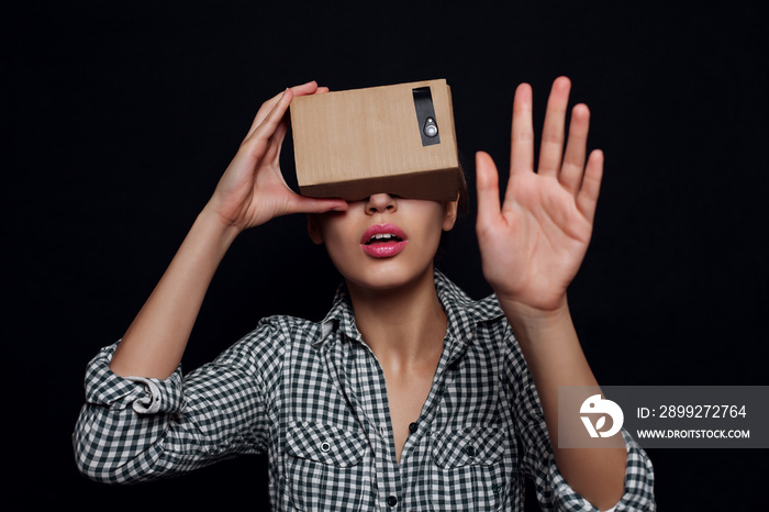 Color shot of a young woman looking through cardboard