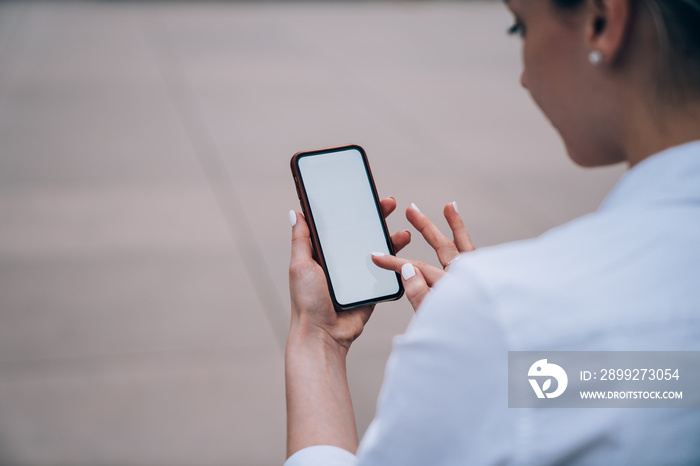 Crop woman checking information on smartphone