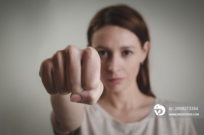 Portrait of young woman looking at camera ready to figh, fist close up