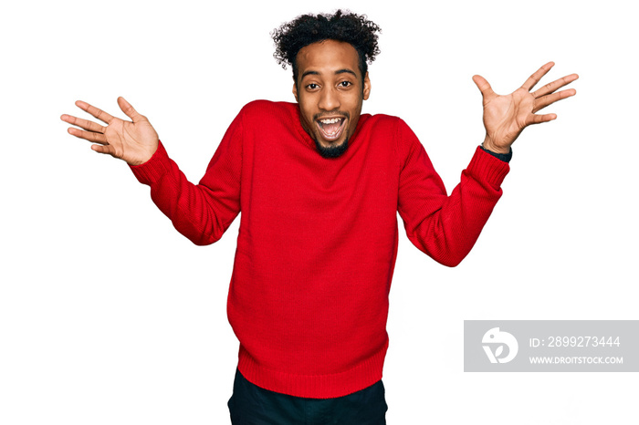 Young african american man with beard wearing casual winter sweater celebrating crazy and amazed for success with arms raised and open eyes screaming excited. winner concept