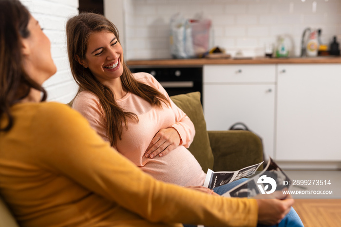 Two women sitting together and looking at several ultrasound images