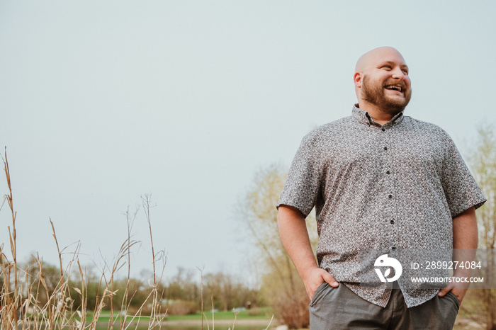 plus size bald man looking away laughing