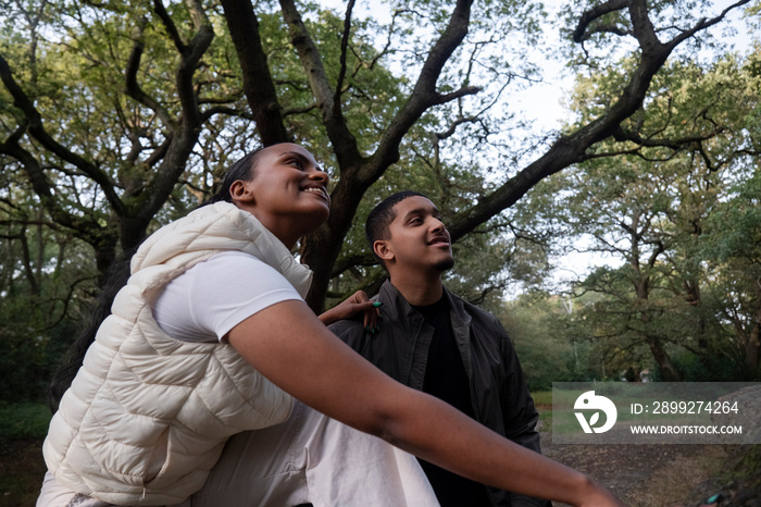 Portrait of smiling couple sitting under tree