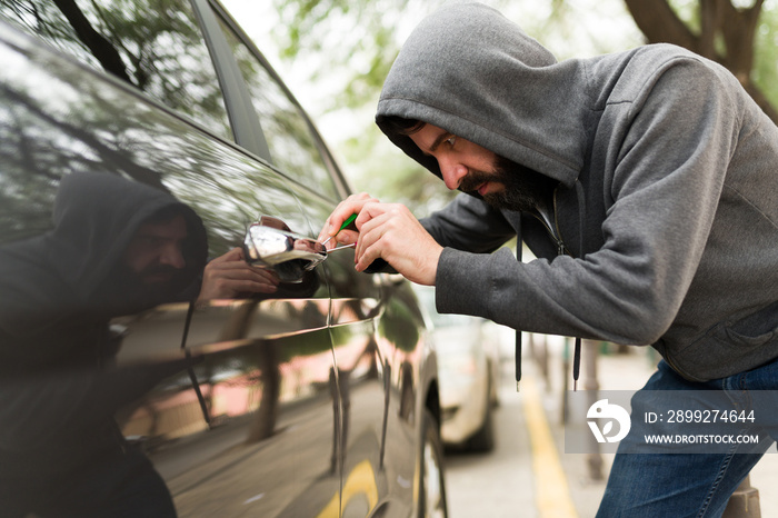 Young man robbing a new car