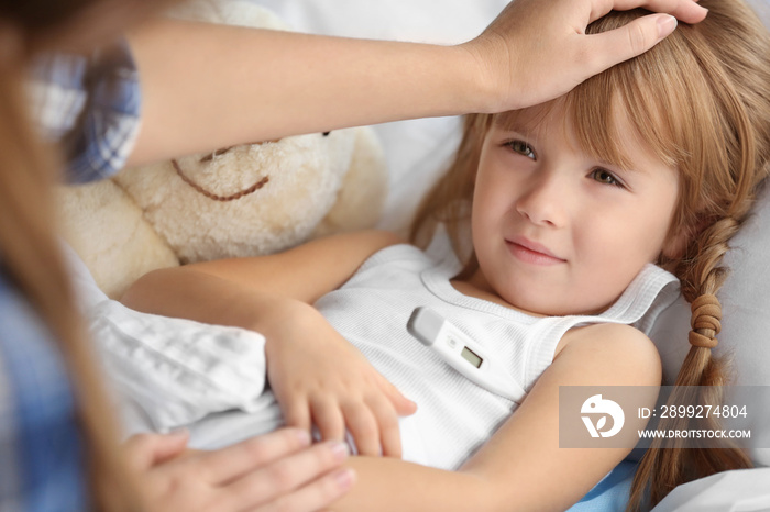 Woman measuring temperature of small sick girl