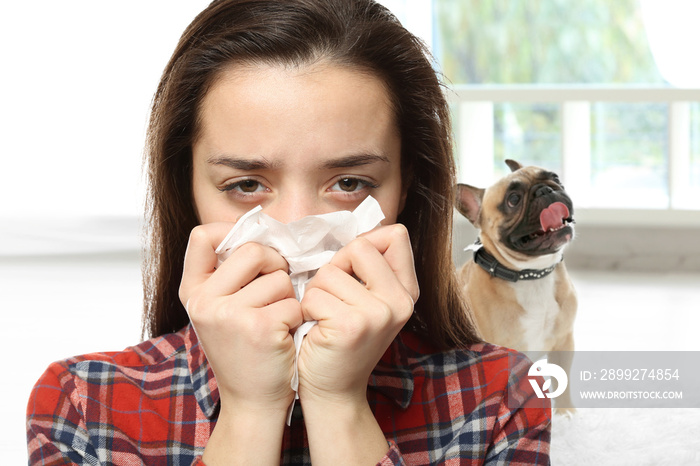 Young ill woman with tissue and pet on background. Concept of allergies to dogs