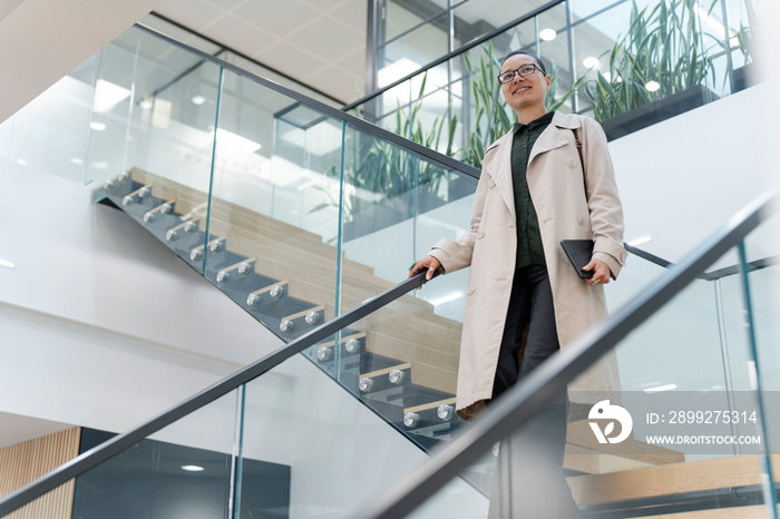 Non binary office worker walking on steps