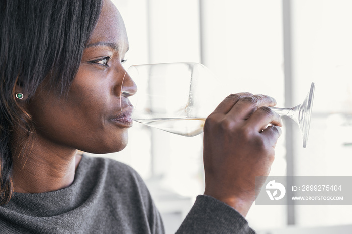 Closeup of African American woman drinking glass of wine