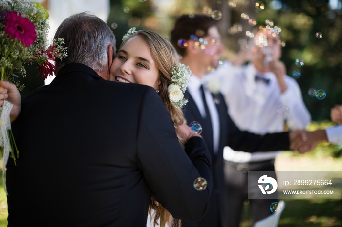 Father embracing his daughter in park