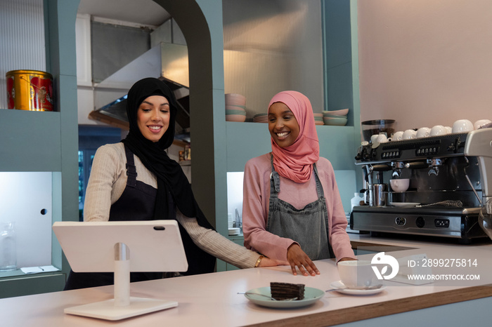 Smiling young women working in cafe