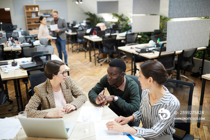 High angle view at multi-ethnic group of people smiling while working together in office, copy space