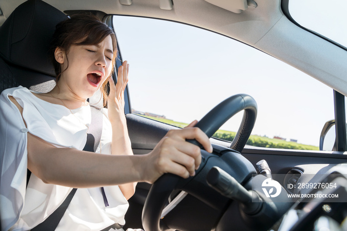 yawning female driver. falling asleep at the wheel concept.