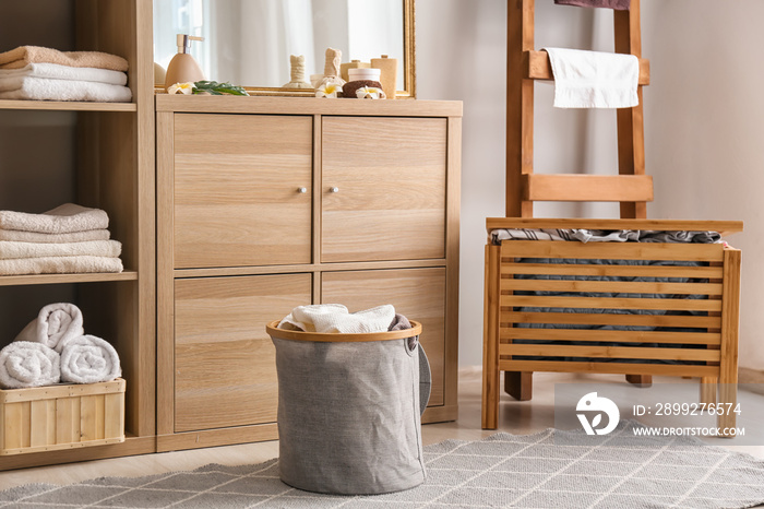 Laundry basket with dirty towels on floor in bathroom