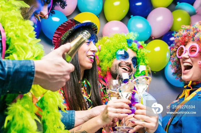 Glückliche Party Freunde feiern karneval und stoßen mit Sekt an.