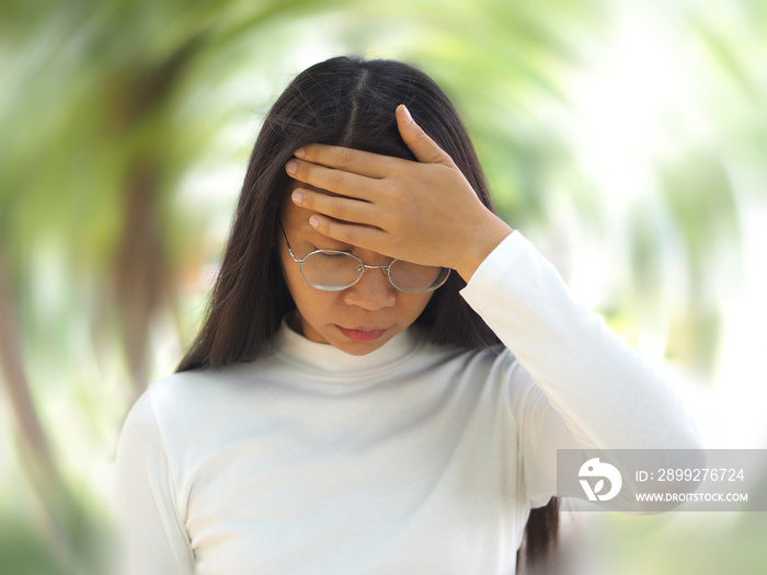 sick building syndrome and vertigo in asian woman and she use hand touching her forehead and symptoms fo pain and suffering on green tree background use for medicine product and health care.