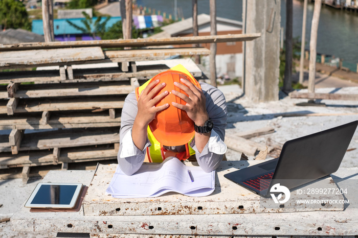 Stress engineer or architect with laptop and tablet holding hands at his head. He is having problems in work. Engineering concept.