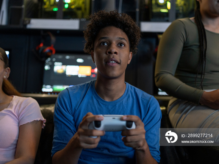 Serious man playing video games with friends in gaming club