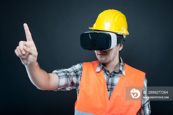 Constructor wearing vr goggles gesturing with index finger